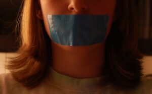 A girl with a blue tape on her mouth.