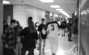 A black and white photo of people walking down a hallway.