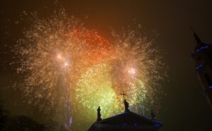 A colorful firework explodes over a church.