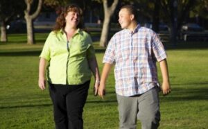 A man and woman walking in a park.