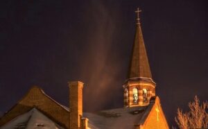 A church with a steeple at night.