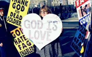 A group of people holding signs that say god is love.