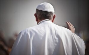 Pope john paul ii walks with his back to the crowd.