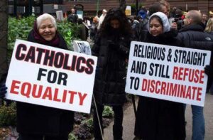 A group of people holding signs that say catholics and straight for equality.