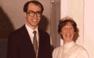 A man in a suit and a woman in a tiara.