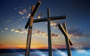 Three crosses on top of a lake at sunset.