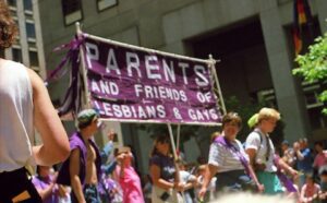 A group of people holding a banner that says parents and friends of lesbians and gays.