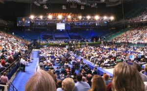 A large crowd of people in a large arena.