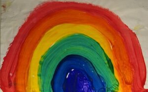 A rainbow painted on a piece of paper.