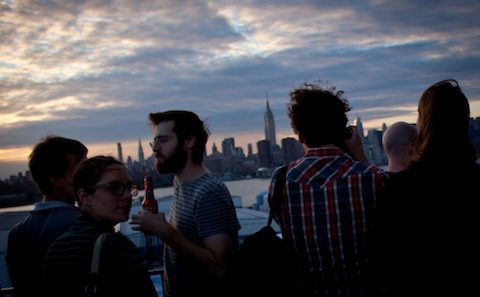 A group of people standing on a rooftop overlooking the city.