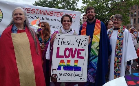 A group of people holding a sign that says this is love all.