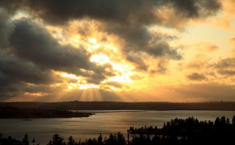 A sunset over a lake with clouds in the background.