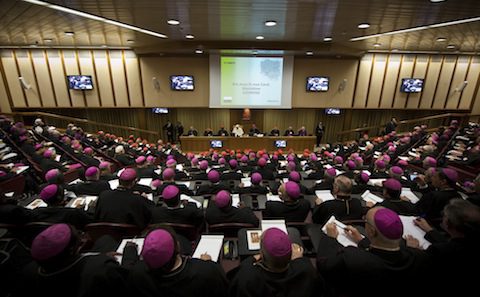 A large group of people in purple robes sitting in a room.