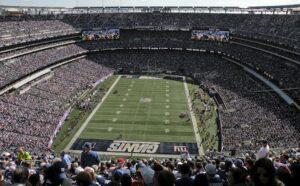 An nfl stadium with many people watching a game.