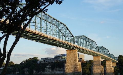 A bridge over a river with trees in the background.