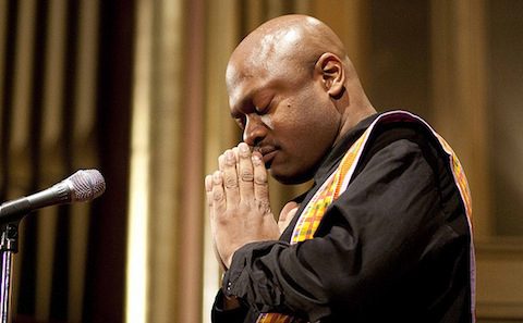 A man praying with his hands together.