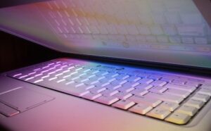 A laptop with a rainbow colored keyboard.