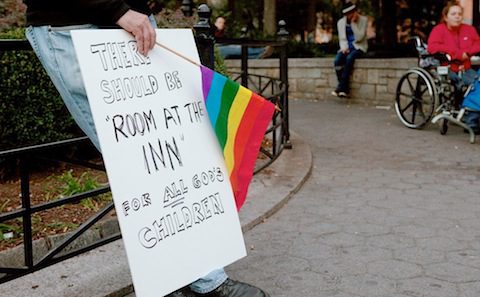 A man holding a sign that says 'room at the inn'.