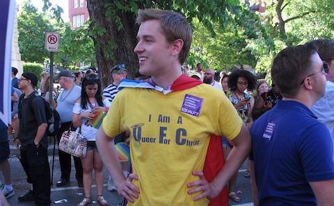 A man in a yellow shirt standing in front of a crowd.