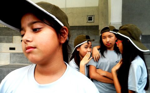 A group of young girls wearing hats.