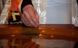 A priest pours water into a bowl.