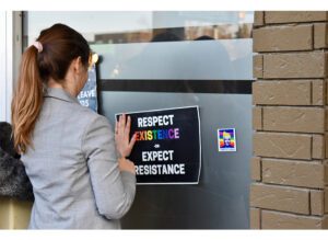 A woman standing in front of a glass door with a sign that says respect.