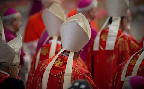 A group of priests wearing red and white robes.