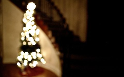 A christmas tree in front of a staircase.