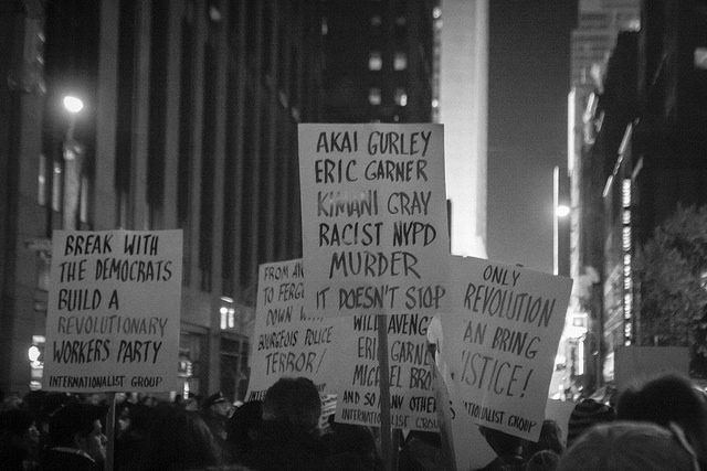 A black and white photo of a group of people holding signs.