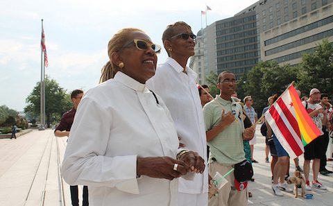 Two people standing next to each other holding flags.