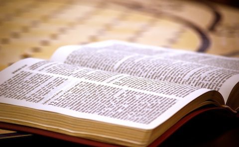 An open bible on top of a table.