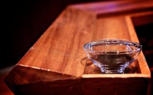 A glass of water sitting on top of a wooden table.
