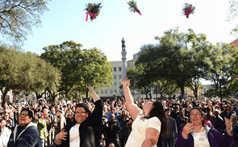 A group of people are throwing flowers in the air.