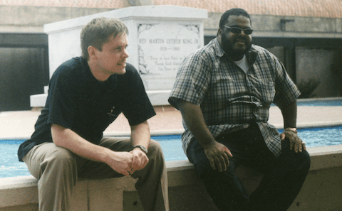 Two men sitting next to a pool.