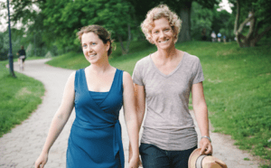 Two women walking down a path in a park.