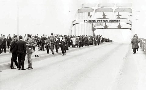 A crowd of people standing on a bridge.