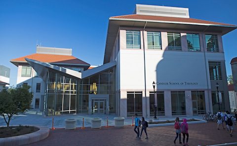 A group of people walking in front of a building.