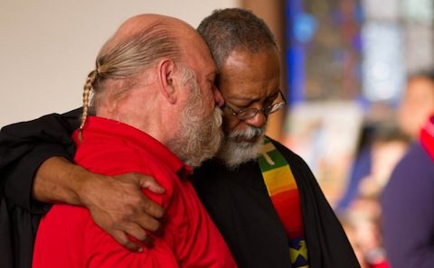 Two men hugging each other in a church.