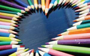 Colored pencils arranged in a heart shape.