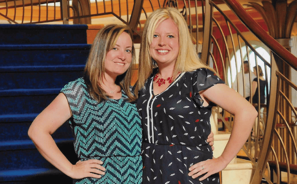 Two women standing next to each other on a staircase.