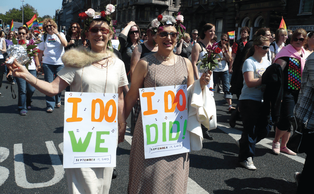 Two women holding signs in a parade.