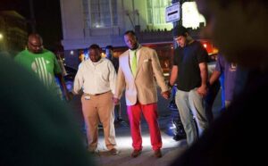 A group of men standing on a street at night.