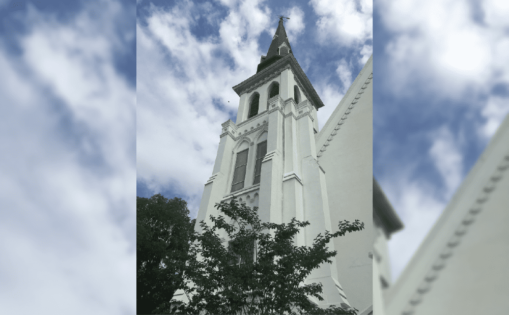 A white church with a steeple in the background.