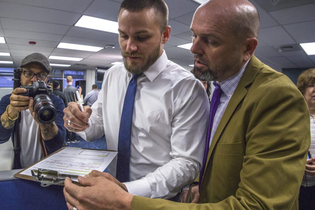 A man in a suit and tie is looking at a piece of paper.