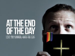 A man holding up a cross with the words at the end of the day.