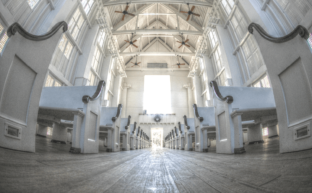 A row of white pews in a church.