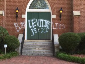 A church with graffiti on the front door.