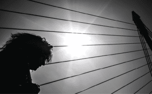 Silhouette of a person on a bridge.