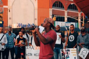 A man holding a microphone in front of a crowd of people.