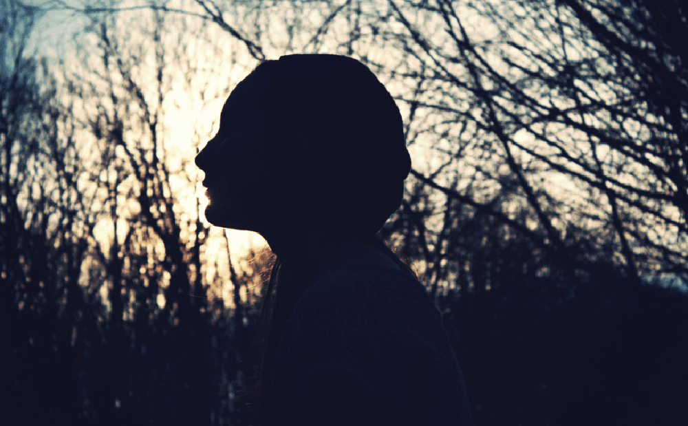 Silhouette of a woman in the woods.